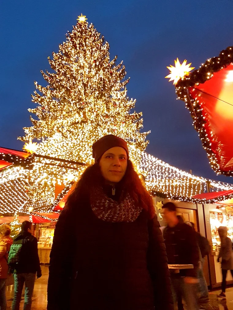Sandra vor dem großen Weihnachtsbaum und den Ständen